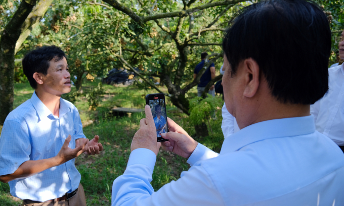 Bộ trưởng Lê Minh Hoan ghi lại những tâm sự của người nông dân bên vườn nông sản đặc trưng của Hưng Yên. Ảnh: Bảo Thắng.