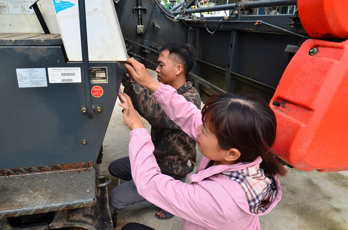 Phien and his wife participated in repairing the machine before going to the fields. Photo: Duong Dinh Tuong.