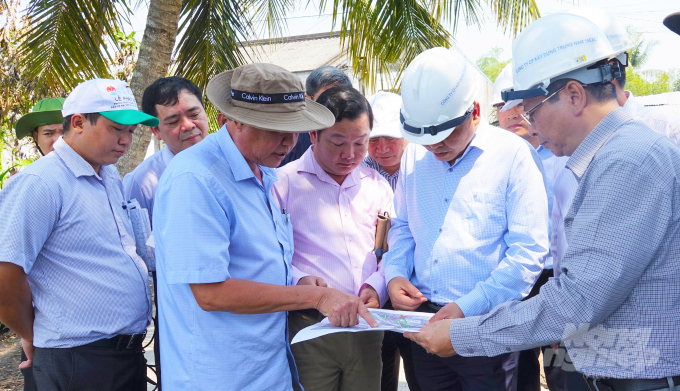 Thứ trưởng Nguyễn Hoàng Hiệp cùng đoàn công tác xem bản đồ về tình hình xâm nhập mặn và phương án phòng chống hạn, mặn của tỉnh Kiên Giang.