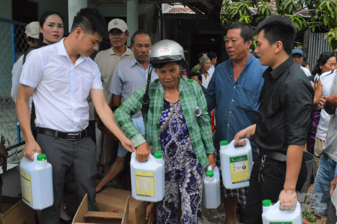 Sau buổi hội thảo, bà con xã viên được tặng sản phẩm sinh học 'Bồ Đề - Mother water' để về xử lý môi trường nuôi tôm quảng canh và tôm - lúa. Ảnh: Trung Chánh.