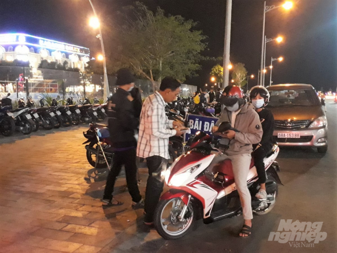 Tối mùng 5 tháng Giêng, hàng trăm người gửi xe máy tại bãi giữ xe trên lề đường để vào bến du xuân Phú Cường đã bị nhân viên chặt chém tới 20 ngàn đồng mỗi chiếc. Ảnh: Trung Chánh.