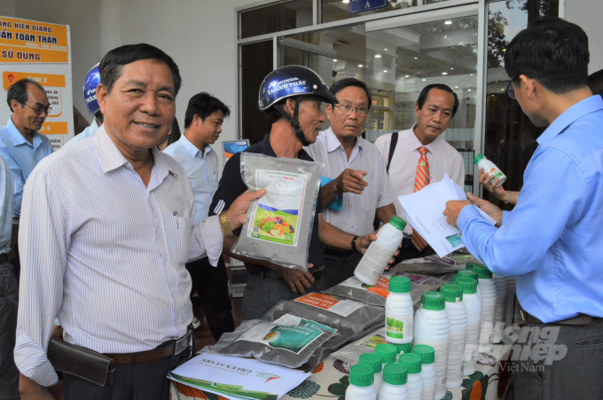 Ông Kim Dương Liễu (bên trái), Giám đốc Hợp tác xã nông sản hữu cơ Rạch Giá, giới thiệu sản phẩm phân, thuốc phục vụ sản lúa lúa, rau màu hữu cơ. Ảnh: Trọng Linh.