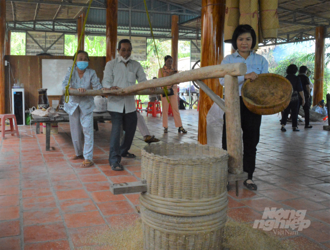 Nhiều người lớn tuổi sau mấy chục năm mới được trải nghiệm lại hoạt động sản xuất lúa, gạo truyền thống mà tuổi thơ đã từng làm. Ảnh: Trung Chánh.