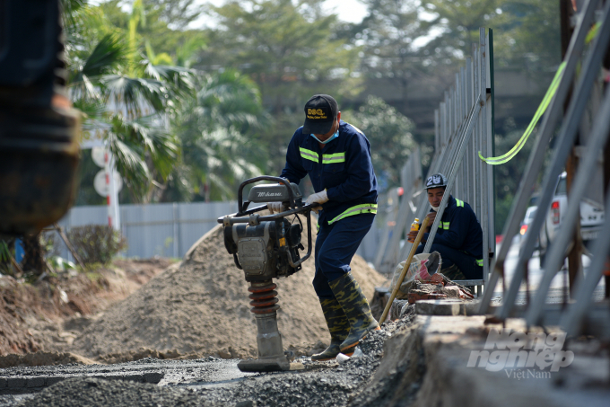 Đơn vị thi công đang thực hiện đầm lu cốt nền để hoàn thành những hạng mục đầu tiên tại đoạn đường nút giao giữa đường Hoàng Quốc Việt và đường Nguyễn Văn Huyên.
