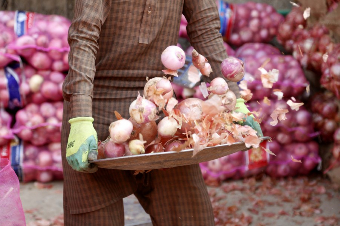 Công nhân làm sạch hành tây tại một chợ rau ở Islamabad, thủ đô của Pakistan, ngày 28/2/2022. Ảnh: Tân Hoa xã.