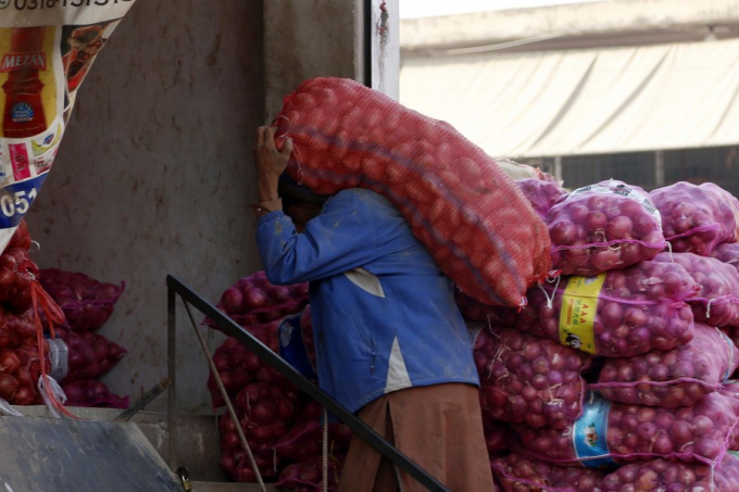 Một công nhân vác một bao hành tây tại một chợ rau ở Islamabad, thủ đô của Pakistan, vào ngày 28 tháng 2 năm 2022. Ảnh: Tân Hoa xã.