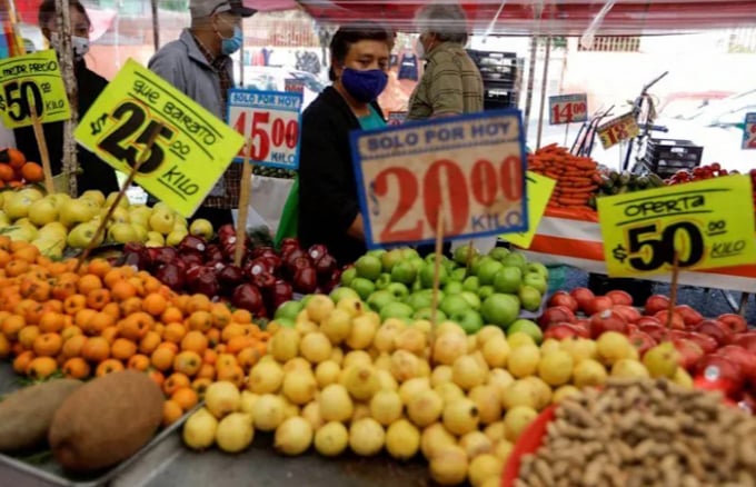 Người tiêu dùng Mexico đi ngang qua một quầy bán trái cây tại một khu chợ đường phố hôm 5/3. Ảnh: Reuters