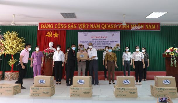 Ông Witthawat Satthatham (vest đen), Phó Tổng giám đốc C.P Việt Nam, trao tặng tượng trưng khẩu trang, nước sát khuẩn cho các trường.