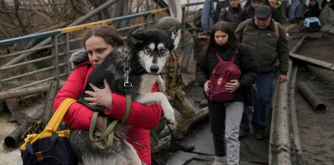 Một phụ nữ Ukraine ôm con thú cưng đi lánh nạn giữa dòng người đang dời khỏi thành phố Irpin hôm 5/3/2022. Ảnh: AP