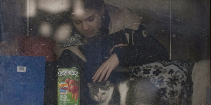 Hình ảnh một cô gái đang vỗ về con mèo ở bên trong toa tàu dời khỏi Lviv, phía tây Ukraine đi lánh nạn hôm 3/3/2022. Ảnh: AP