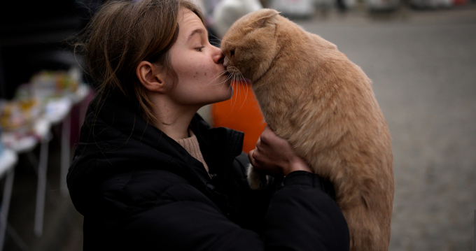 Cô gái Ukraine có tên Julia Lazarets đang ôm hôn con mèo cưng Gabriel sau khi dời khỏi quê nhà tại nhà ga Przemysl (Ba Lan) đúng ngày Quốc tế Phụ nữ (8/3/2022). Ảnh: AP