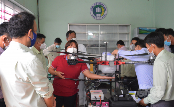 Farmers learn about the line of drones manufactured in South Korea, used to spray pesticides, which will help reduce the number of pesticides in each spray, increasing the efficiency of pesticide use. Photo: Trung Chanh.
