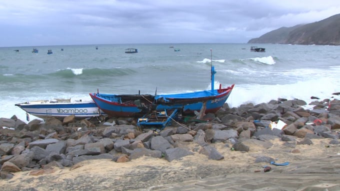 Chiếc tàu cá và chiếc ca nô du lịch của ngư dân xã Nhơn Lý (thành phố Quy Nhơn, Bình Định) bị sóng lớn đánh dạt vào bờ. Ảnh: V.Đ.T.