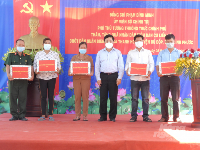 Phó Thủ tướng thường trực Chính phủ Phạm Bình Minh tặng quà nhân dân điểm dân cư liền kề chốt dân quân biên giới xã Thanh Hòa. Ảnh: Trần Trung.