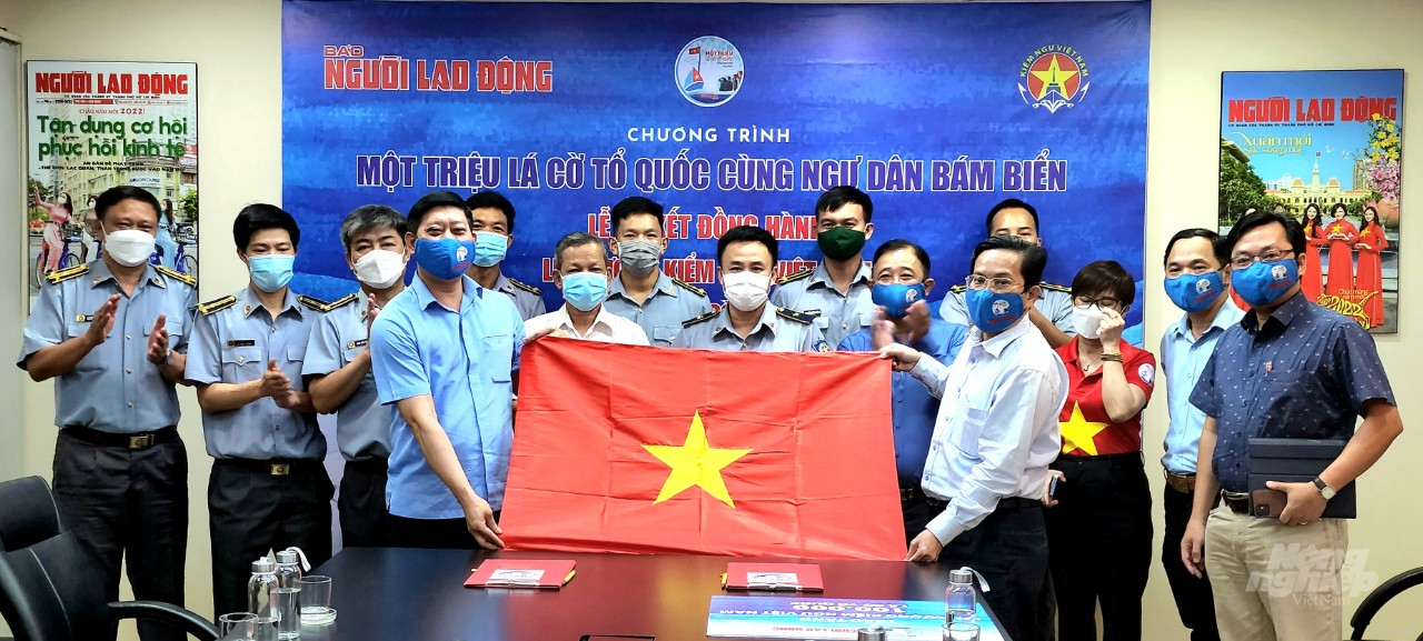  Cục trưởng Cục Kiểm ngư Việt Nam đón nhận tượng trưng 100.000 lá cờ Tổ quốc của Báo Người Lao Động trao tặng. Ảnh: Minh Sáng.