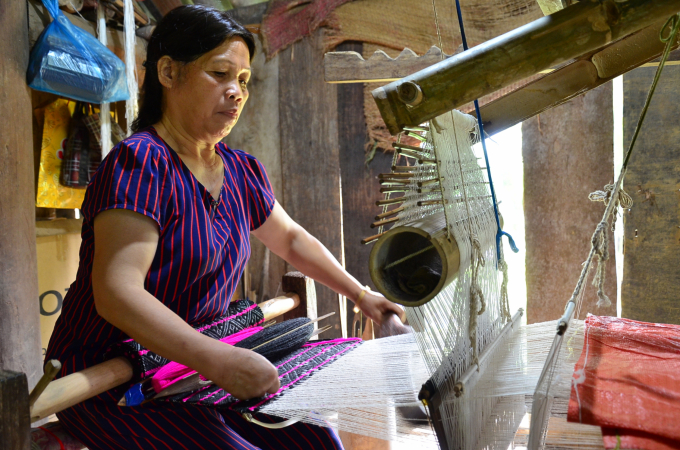 Ms. Nguyen Thi Y works night and day by the loom weaving brocade. Photo: Duong Dinh Tuong.