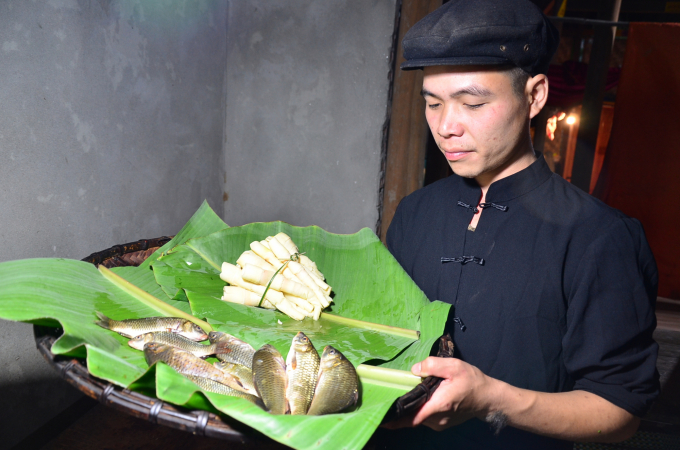 Chau Duc Anh - owner of Anh The homestay carrying field carps and bamboo shoots. Photo: Duong Dinh Tuong.