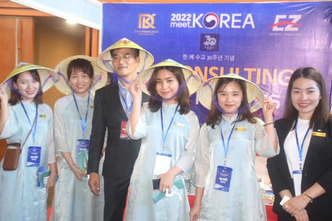 Korean guests wearing Vietnamese conical hats at a booth displaying Korean products at the event 'Meet Korea 2022'. Photo: V.D.T.
