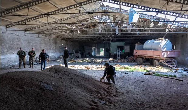 Local government officials and Ukrainian soldiers inspect a grain warehouse shelled by Russian forces in Novovorontsovka this month. Photo: John Moore/Getty Images