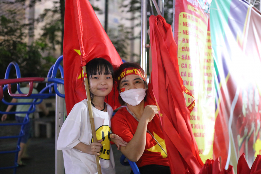 Các em nhỏ phấn khích cùng cha mẹ cổ vũ đội tuyển Việt Nam. Ảnh: Hùng.