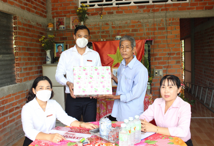 Ông Đặng Trung Quân, Phó Giám đốc ngân hàng Agribank TX Cai Lậy, trao quà và chúc mừng gia đình ông Nguyễn Văn Lù có ngôi nhà mới. Ảnh: Quốc Trí.
