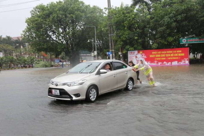 Cảnh sát giao thông Công an Vĩnh Phúc giúp đỡ các phương tiện thoát khỏi đoạn ngập nước.