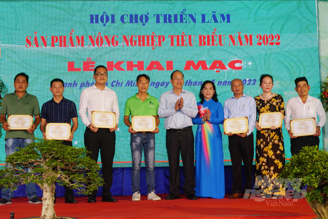Ông Nguyễn Hồ Hải, Phó Bí thư Thành ủy TP.HCM và bà Nguyễn Thanh Xuân (đứng giữa) trao giấy chứng nhận cho các đơn vị, doanh nghiệp, hộ nông dân tham gia Hội chợ nhiều năm liền.