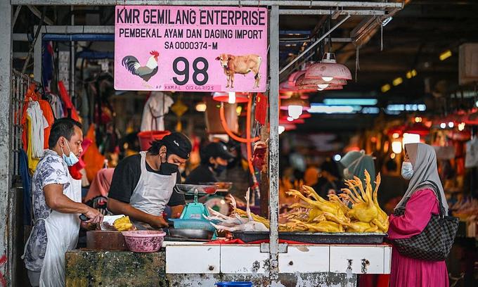 Khách hàng chờ mua thịt gà tại một khu chợ ở thủ đô Kuala Lumpur. Ảnh: AFP