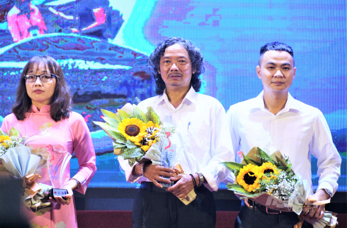 Author Nguyen Tam Phung (central) of the VAN won the Consolation Prize for the work 'Crossing the water to save people in flood'. Photo: Pham Hieu.