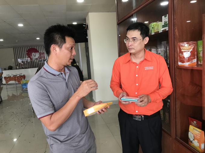 Anh Trần Duy Linh trao đổi với khách hàng về các sản phẩm chế sâu từ trái dừa sáp của Vicosap. Ảnh: Minh Đảm.