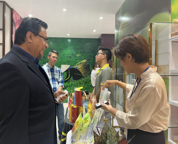 Tiến sĩ Halim Bin Husin, Chủ tịch Liên hiệp các phòng thương mại Malaysia tìm hiểu thông tin một số sản phẩm của Việt Nam trưng bày tại buổi hội thảo. Ảnh: Nguyễn Thủy.