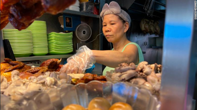 Chicken-rice seller Madam Tong prepares a dish for a customer. Photo: CNA