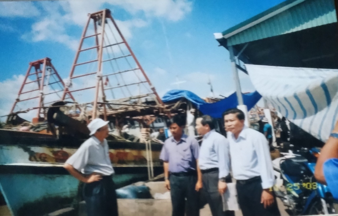 Bộ trưởng Tạ Quang Ngọc (bên trái) trao đổi tình hình khai thác với ông Năm Gành sau khi khảo sát một tàu cá. Ảnh: Tư liệu.