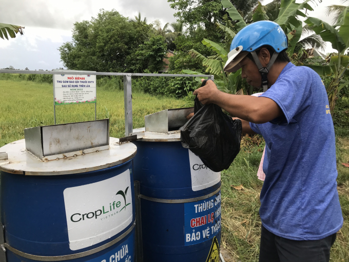 Farmers bringing used pesticide bottles and packaging to the model's container. Photo: Minh Dam.