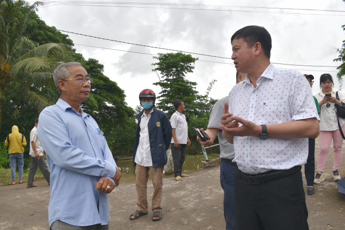 Mr. Huynh Tan Dat, Deputy Director of the Department of Plant Protection discussing with farmers about the practical efficiency of the model of collecting used pesticide bottles and packaging. Photo: Minh Dam.