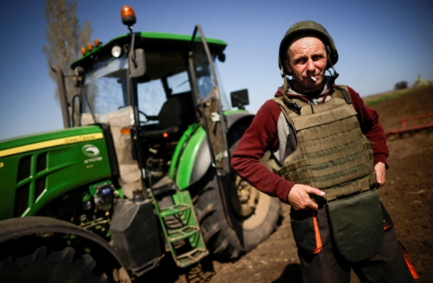 A Ukrainian farmer wears body armour and helmet while working fields in the Zaporizhzhia region, Ukraine in April 2022. Photo: RT