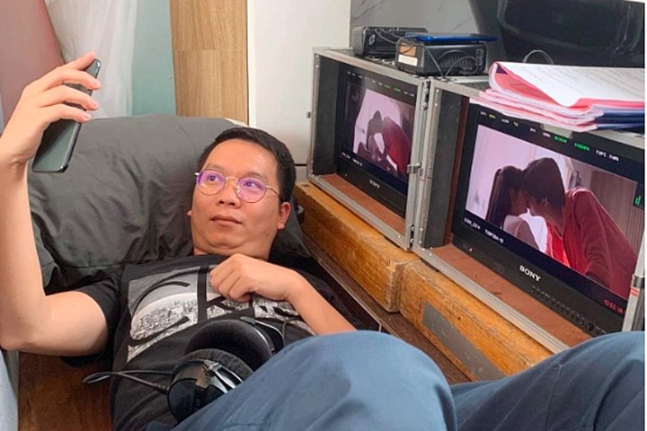 Đạo diễn Bùi Tiến Huy chụp cùng màn hình monitor có cảnh Doãn Quốc Đam hôn Ngọc Huyền.
