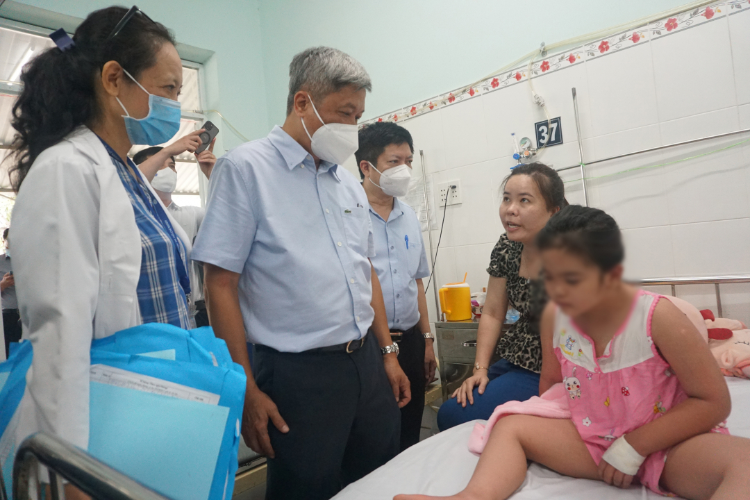 Thứ trưởng Nguyễn Trường Sơn hỏi thăm tình hình điều trị sốt xuất huyết của bệnh nhi tại Bệnh viện Quận 8. Ảnh: Nguyễn Thủy.