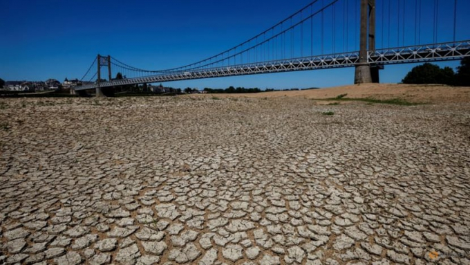 Cracked and dry earth is seen in the wide riverbed of the Loire River near the Anjou-Bretagne bridge as a heatwave hits Europe, in Ancenis-Saint-Gereon, France, Jun 13, 2022. Photo: Reuters/Stephane Mahe