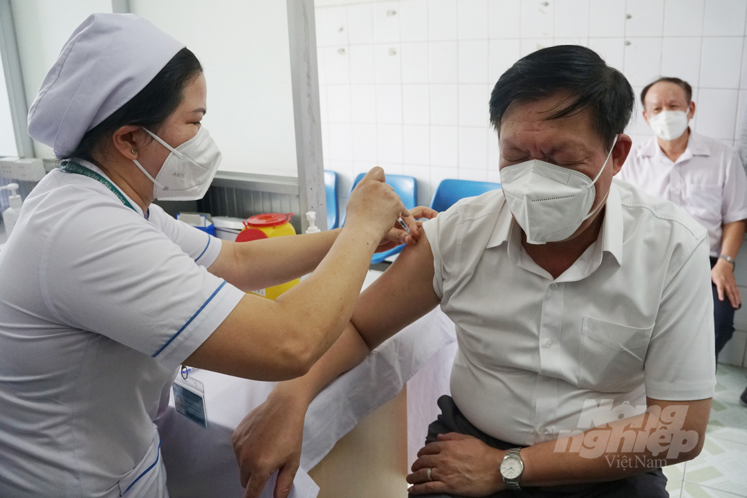 Thứ trưởng phụ trách điều hành Bộ Y tế Đỗ Xuân Tuyên cũng tiêm mũi nhắc lại vacxin phòng Covid-19 tại Bệnh viện Bệnh Nhiệt đới TP.HCM sáng 30/6. Ảnh: Nguyễn Thủy.
