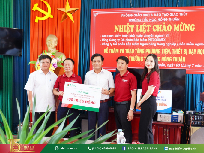 Đại diện Bảo hiểm Agribank tra phần quà trị giá 100 triệu đồng để xây dựng phòng học tin học đạt chuẩn cho học sinh Trường tiểu học Hồng Thuận (Giao Thủy, Nam Định). 