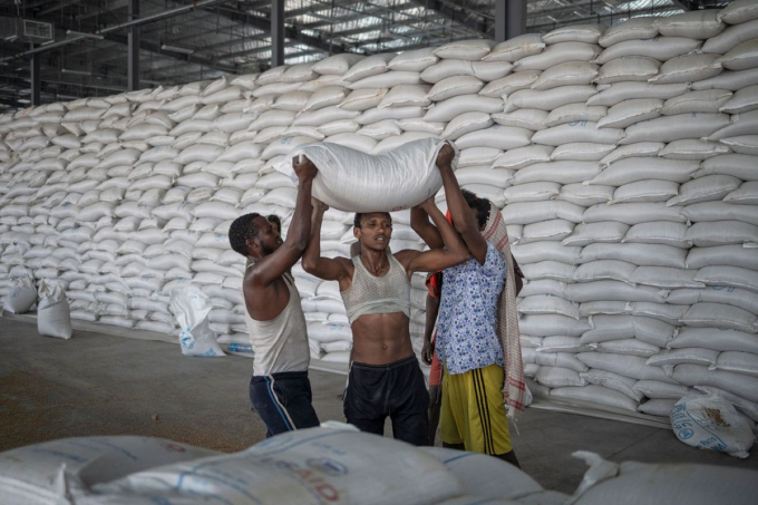Men help carry a bag of wheat to be loaded on an aid truck in a UN storehouse on the outskirts of Semera, Afar region, Ethiopia, on May 15, 2022. Photo: Agencies