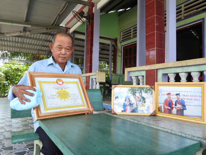 Ông Trần Ngọc Oanh bên căn nhà khang trang cùng những bằng khen và hình ảnh người con trai đáng tự hào. Ảnh: Trần Trung. 