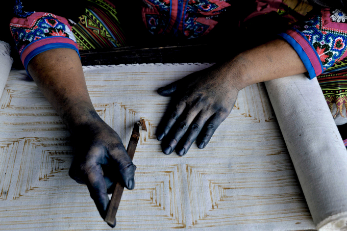 Khi những tấm thổ cẩm ra đời, bà con người Mông dùng sáp ong để vẽ họa tiết trên vải. Các nét vẽ tỉ mỉ bằng sáp ong sẽ dần dần lộ ra một cách rõ nét, tinh tế. Với những phụ nữ có kinh nghiệm, bàn tay họ thường bị màu chàm bám vào da. Màu da chỉ trở lại bình thường trong một thời gian dài sau khi họ dừng công việc nhuộm vải.