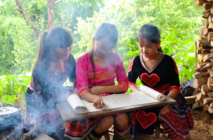 Những bé gái trong bản được các bà, các mẹ truyền dạy cách vẽ sáp ong, nhuộm vải để các thế hệ sau này có thể gìn giữ việc làm thổ cẩm, may trang phục truyền thống.