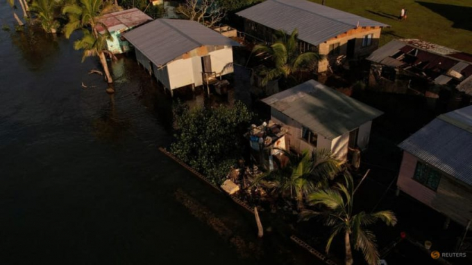 Seawater floods past an ineffective sea wall into the community of Veivatuloa Village, Fiji, July 16, 2022. Leaders of 15 low-lying Pacific island nations declared climate change their 'single greatest existential threat' at a mid-July summit in Fiji's capital, Suva. Facing some of the most direct effects of climate change, they want developed nations, who contributed the most to global warming, not only to curb their emissions but to pay for the steps that islanders must take to protect their people from rising sea levels. Photo: REUTERS/Loren Elliott