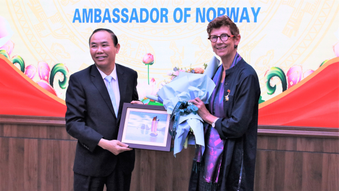 Deputy Minister Phung Duc Tien presents the commemorative medals and souvenirs to Mrs. Grete Lochen. Photo: Hoang Giang.