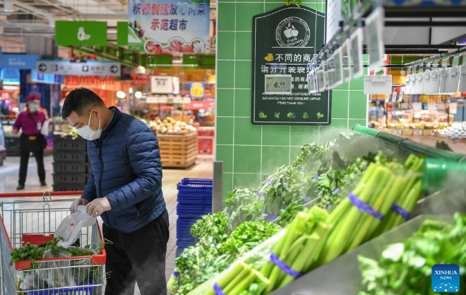Một người đàn ông chọn mua rau xanh tại siêu thị ở Cát Lâm, đông bắc Trung Quốc hôm 16 tháng 3 năm 2022. Ảnh: Xinhua