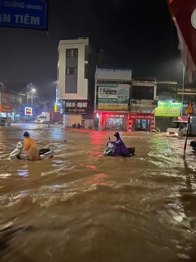 Tại phường Hà Khẩu (TP Hạ Long) nước dâng cao ngập cả bánh xe khiến cho người dân đi lại vô cùng khó khắn. Ảnh: QMG
