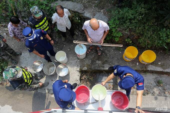 Lực lượng lính cứu hỏa đang phân phát nước sinh hoạt cho người dân làng Loudi, tỉnh Hồ Nam, miền Trung Trung Quốc hôm 24/8. Ảnh: AFP 